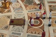 Pope Francis prepares to lie down in prayer prior to celebrate Mass for the Passion of Christ, in St. Peter's Basilica at the Vatican, Friday, April 19, 2019. Pope Francis began the Good Friday service at the Vatican with the Passion of Christ Mass and hours later will go to the ancient Colosseum in Rome for the traditional Way of the Cross procession. (Tiziana Fabi/Pool Photo via AP)