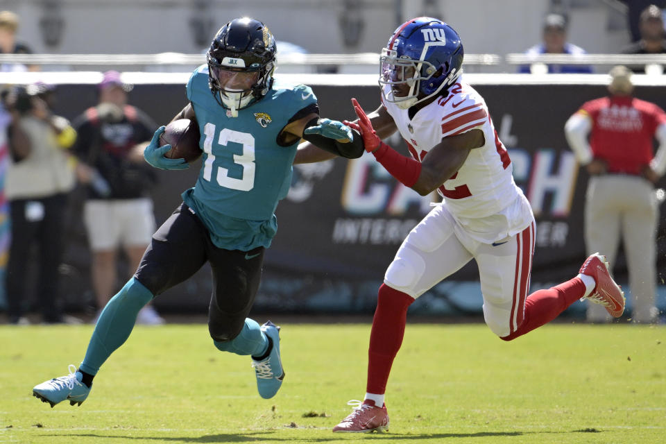 Jacksonville Jaguars wide receiver Christian Kirk (13) pushes past New York Giants cornerback Adoree' Jackson (22) after a catch during the first half of an NFL football game Sunday, Oct. 23, 2022, in Jacksonville, Fla. (AP Photo/Phelan M. Ebenhack)