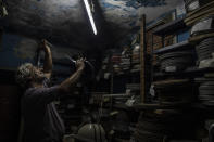In this Wednesday, June 3, 2020 photo, projector operator Pavlos Lepeniotis checks the quality of a movie film inside a warehouse at the Zephyros open-air cinema that specializes in films from past decades in the Petralona district in central Athens. Lepeniotis has worked in movie theaters since age 12. (AP Photo/Petros Giannakouris)