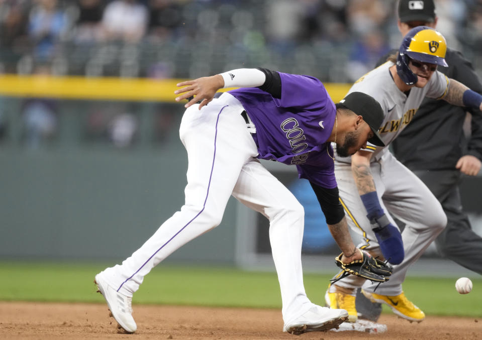 Colorado Rockies second baseman Harold Castro, front, tries to field the throw as Milwaukee Brewers' Bryce Turang steals second base in the second inning of a baseball game Tuesday, May 2, 2023, in Denver. (AP Photo/David Zalubowski)