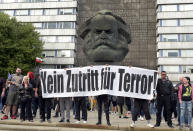 Protesters gather for a far-right protest in front of a Karl Marx monument in Chemnitz, Germany, Monday, Aug. 27, 2018 after a man has died and two others were injured in an altercation between several people of "various nationalities" in the eastern German city of Chemnitz on Sunday. Slogan reads 'No Access For Terror'. (AP Photo/Jens Meyer)