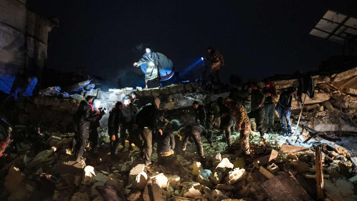 Civilians and fighters sift through the rubble of a collapsed building looking for victims and survivors following an earthquake in the town of Jandaris, in the countryside of Syria's northwestern city of Afrin in the rebel-held part of Aleppo province, early on February 6, 2023. - At least 42 have been reportedly killed in north Syria after a 7.8-magnitude earthquake that originated in Turkey and was felt across neighbouring countries. (Photo by Rami al SAYED / AFP)