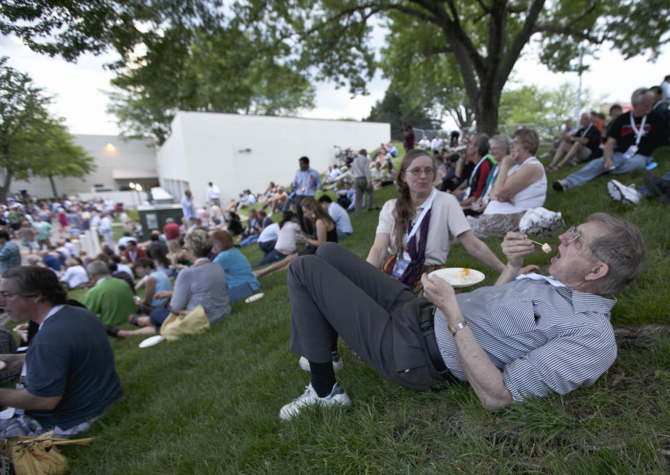 Phil Martin of Minneapolis is watched by his wife Linda as he snacks with other shareholders outside the Berkshire-owned Borsheims jewelry store in Omaha, Neb., Friday, May 4, 2012. Berkshire Hathaway is expected to have 30,000 shareholders come to Omaha for it's annual shareholders meeting this weekend. (AP Photo/Nati Harnik)