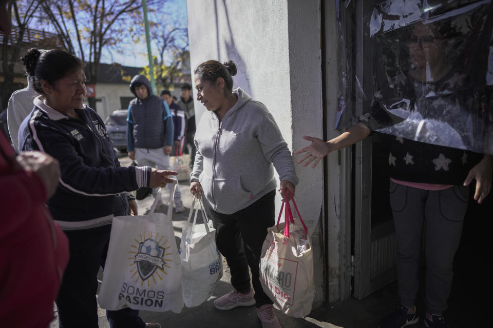 Women carry away bags of food given out by a soup kitchen that serves hot meals in Buenos Aires, Wednesday, May 10, 2023. Many people rely on daily food handouts amid galloping inflation. (AP Photo/Victor R. Caivano)