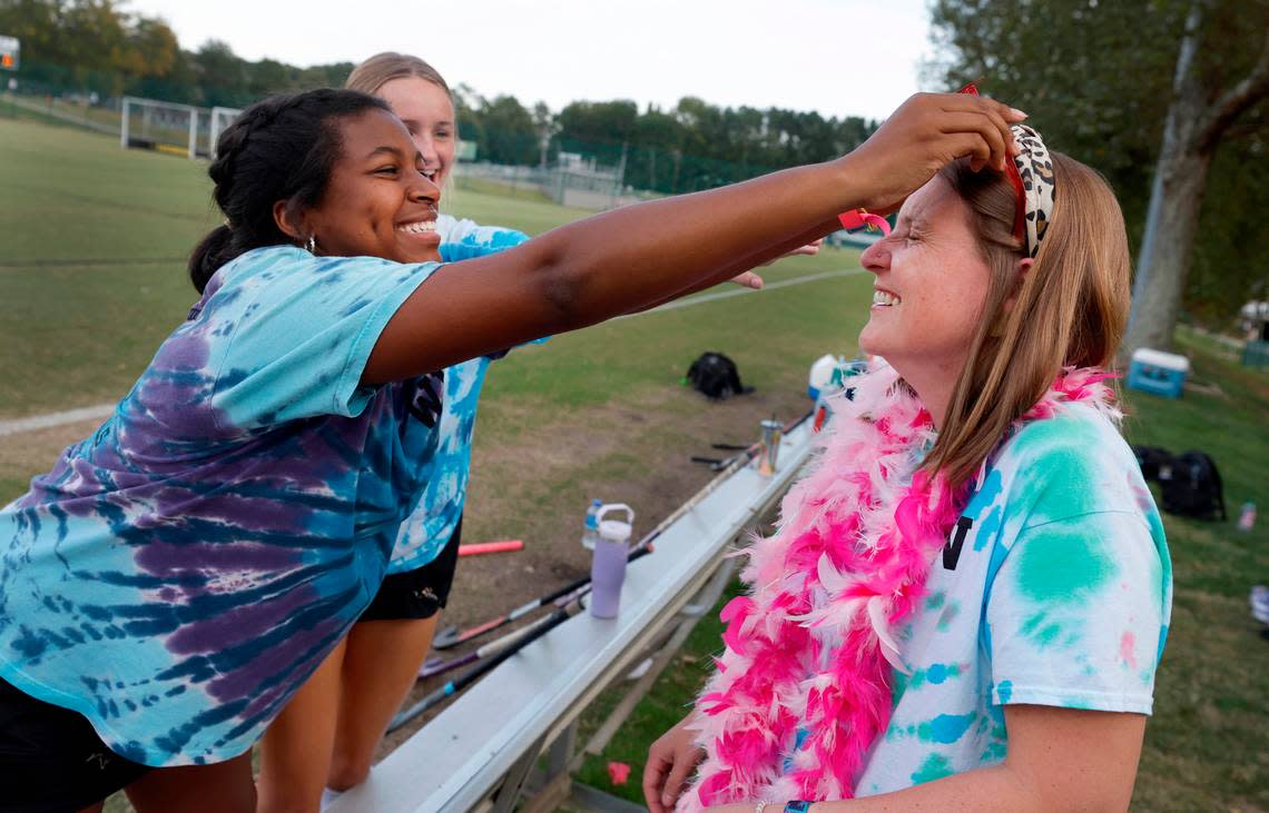 Ravenscroft High School’s Lexie Dozier playfully puts novelty sunglasses on Whitford Wooten before senior day festivities for Ravenscroft field hockey Tuesday, Oct. 10, 2023. Wooten, an assistant field hockey coach, has ALS (amyotrophic lateral sclerosis or Lou Gehrig’s disease), a progressive neurodegenerative disease.