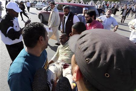 ATTENTION EDITORS - VISUAL COVERAGE OF SCENES OF INJURY OR DEATH People carry a man who was injured when Libyan militiamen opened fire into a crowd of protesters in Tripoli November 15, 2013. REUTERS/Stringer