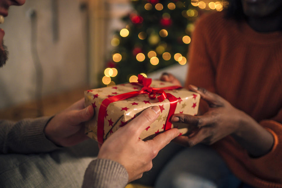 Young African woman receiving a present from her boyfriend on Christmas