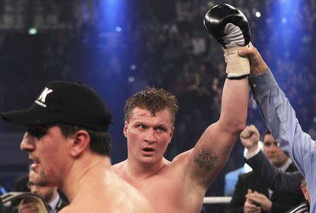 FILE PHOTO - Alexander Povetkin (C) of Russia poses after winning World Boxing Association (WBA) heavyweight world championship fight against Marco Huck (L) of Germany in Stuttgart February 25, 2012. REUTERS/Alex Domanski/File Photo