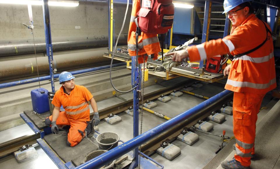 A worker receives instructions from an engineer during the installation of the railway tracks in the NEAT Gotthard Base tunnel near Erstfeld