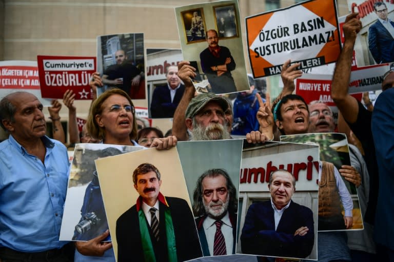 Protesters hold pictures of jailed Cumhuriyet journalists along with signs reading, "Free media cannot be silenced" during a demonstration against their arrest outside the courthouse of Istanbul on July 28, 2017