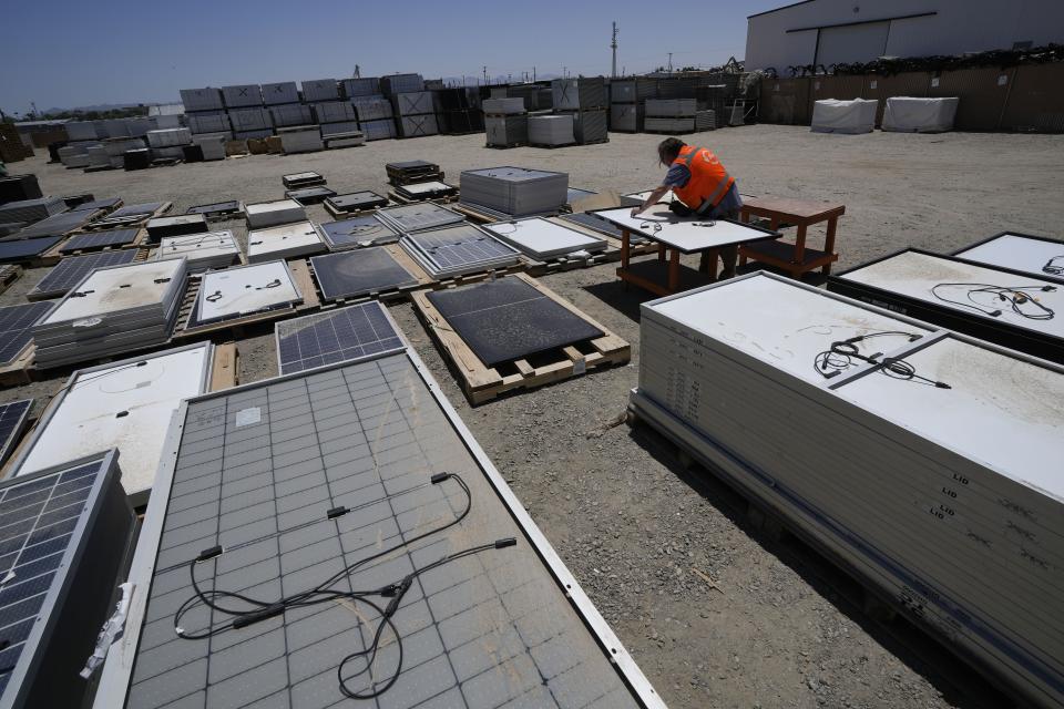 Dwight Clark inspects a used solar panel at We Recycle Solar on Tuesday, June 6, 2023, in Yuma, Ariz. North America’s first utility-scale solar panel recycling plant opened to address what founders of the company call a “tsunami” of solar waste, as technology that became popular in the early 2000s rapidly scales up. (AP Photo/Gregory Bull)