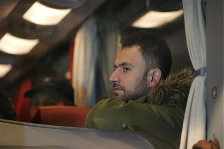 A refugee sits inside a bus arriving from the Bavarian town of Landshut to the Chancellery building in Berlin, Germany, January 14, 2016. REUTERS/Fabrizio Bensch