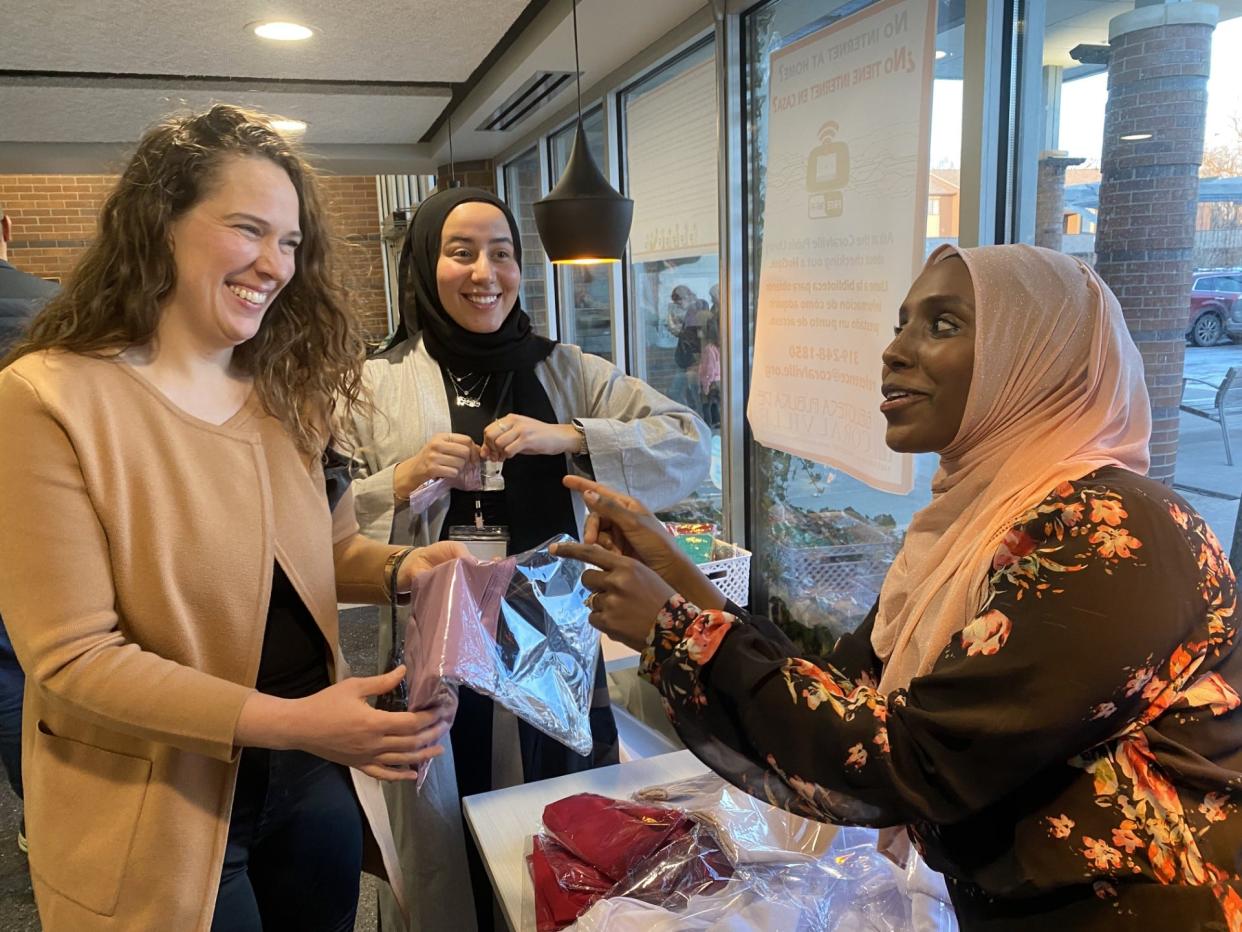 Samira Abdalla (right), one of the organizers of World Hijab Day at the Coralville Public Library, shows Coralville resident and University of Iowa graduate student Margaux Hovda (left), how the faith-inspired head coverings are worn.