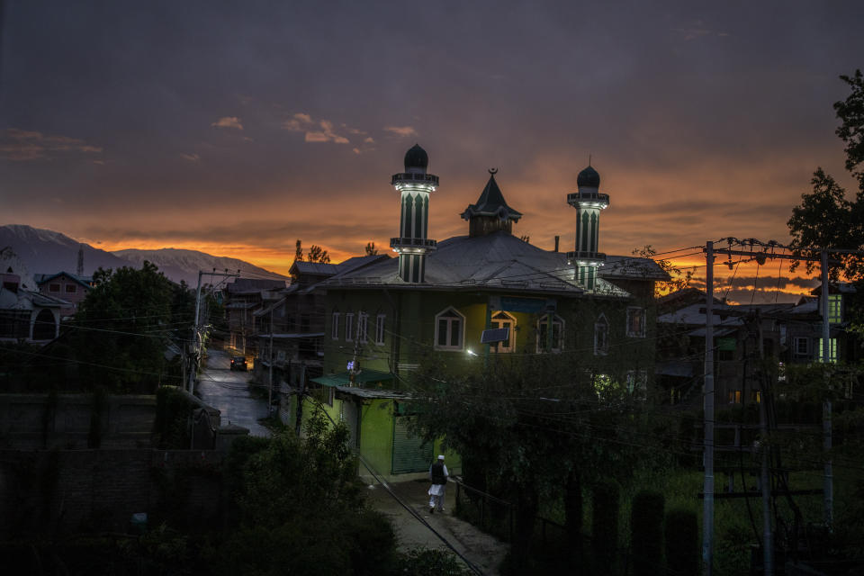 A Kashmiri Muslim walks towards a mosque during sunset in Srinagar, India, Friday, May 14, 2021. (AP Photo/Altaf Qadri)