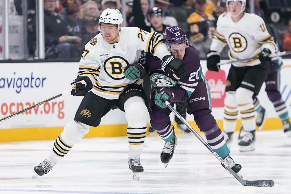 Anaheim Ducks right wing Brett Leason, front right, collides with Boston Bruins defenseman Hampus Lindholm, left, during the first period of an NHL hockey game Sunday, Oct. 22, 2023, in Anaheim, Calif. (AP Photo/Ryan Sun)