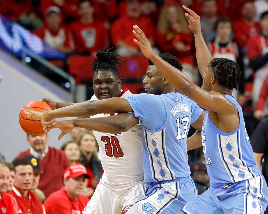 North Carolina’s Jalen Washington and Harrison Ingram pressure N.C. State’s DJ Burns Jr. during the first half of the Tar Heels’ 67-54 win at PNC Arena on Wednesday, Jan. 10, 2024, in Raleigh, N.C.