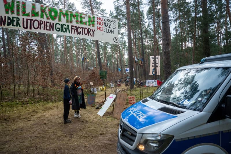 A police car drives past a protest camp where hundreds of activists protest Tesla's planned expansion outside Berlin. Christophe Gateau/dpa