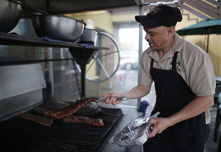 Cresencio Lara places pork ribs on the grill at The Outdoor Grill in Culver City, Los Angeles, California April 10, 2014. REUTERS/Lucy Nicholson