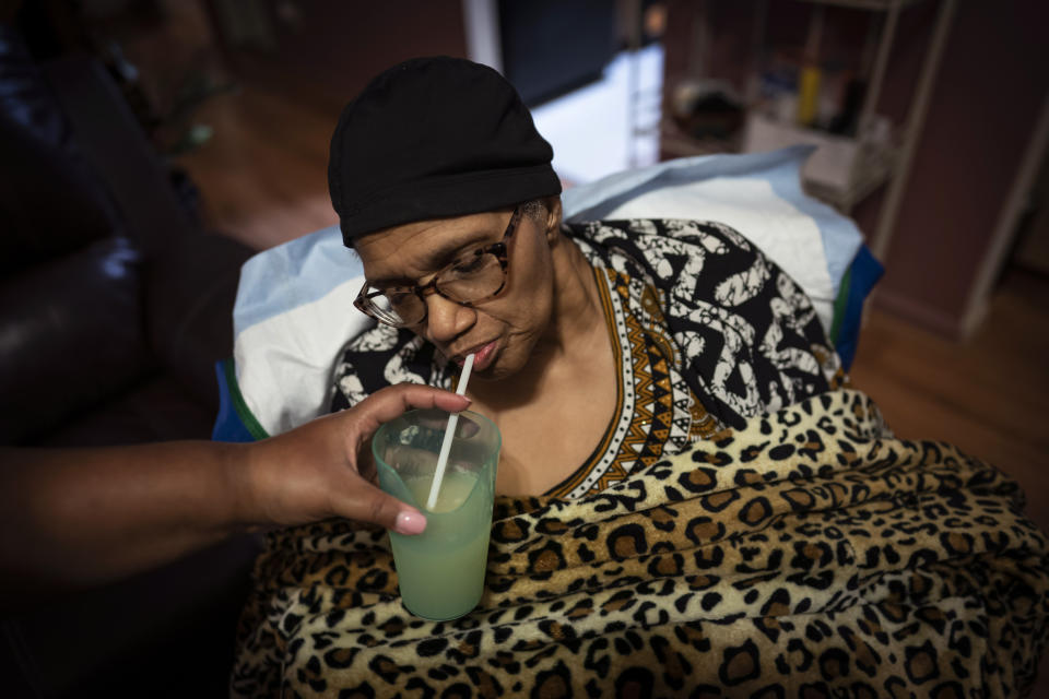 Constance Guthrie drinks from a glass of lemonade held by her daughter, Jessica Guthrie, during dinner in Fredericksburg, Va., on Monday, Sept. 19, 2022. For a woman who had grown accustomed to being so independent, it was hard for her to accept that she needed help. (AP Photo/Wong Maye-E)