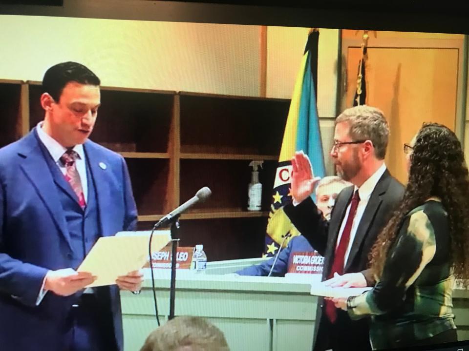 N.J. state Sen. Michael Testa Jr. reads the oath of office to Cumberland County Commissioner Douglas Albrecht (center) at the Jan. 6, 2023 Board of Commissioners reorganization. Albrecht takes the oath with his wife beside him.