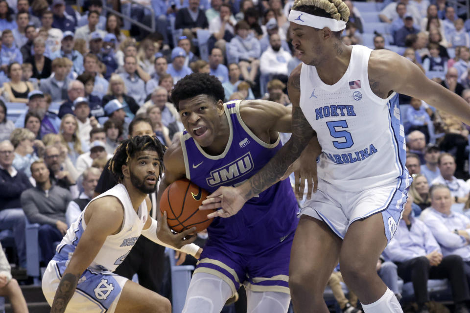 James Madison forward Mezie Offurum, center, drives against North Carolina guard R.J. Davis, left, and forward Armando Bacot (5) during the second half of an NCAA college basketball game, Sunday, Nov. 20, 2022, in Chapel Hill, N.C. (AP Photo/Chris Seward)