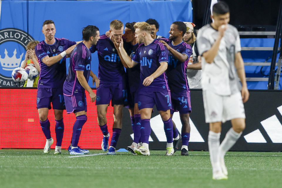 Charlotte FC forward Karol Swiderski, third from left, is congratulated after he scored against Toronto FC during the first half of an MLS soccer match in Charlotte, N.C., Wednesday, Oct. 4, 2023. (AP Photo/Nell Redmond)