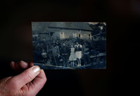 Marthe Rigault, de 87 años, de Graignes, en la región de Normandía, posa sosteniendo una copia de una fotografía tomada un par de semanas después del Día D y mostrándose entre familiares y soldados estadounidenses mientras asiste a una entrevista con Reuters en Graignes, Francia, el 15 de mayo de 2019. REUTERS/Christian Hartmann/Files