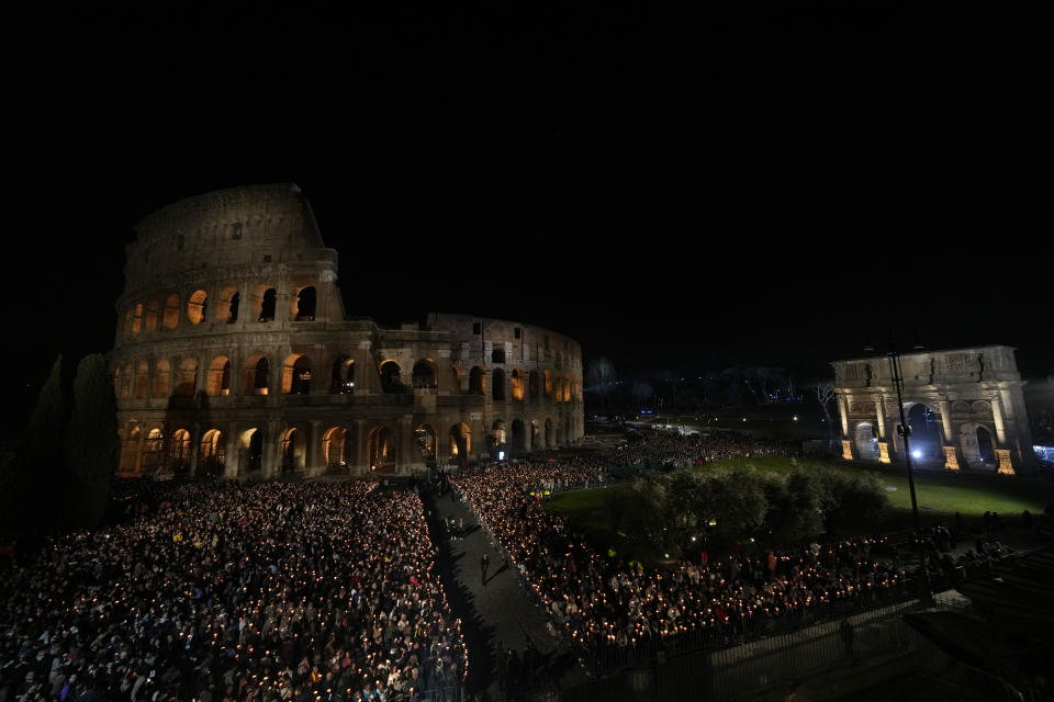 People hold candles in front of the Colosseum during a Via Crucis (Way of the Cross) torchlight procession on Good Friday, in Rome, Friday, March 29, 2024. (AP Photo/Andrew Medichini)