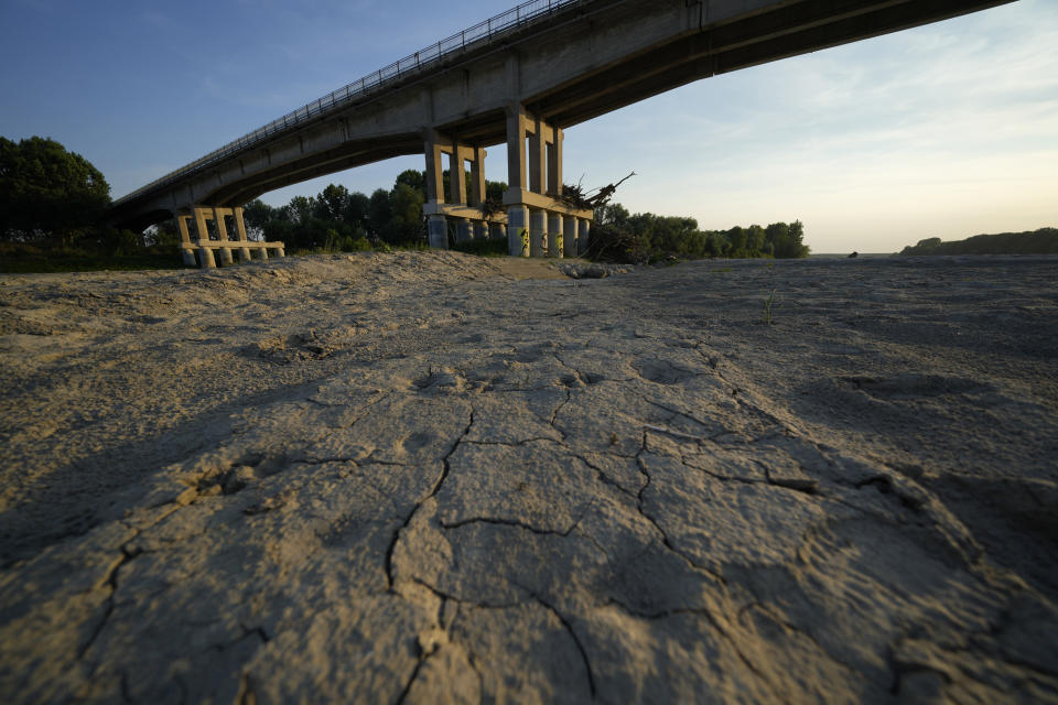 Dry cracked land sits under a bridge in Boretto on the bed of the Po river in Italy, Wednesday, June 15, 2022. TThe drying up of the river is jeopardizing drinking water in Italy's densely populated and highly industrialized districts and threatening irrigation in the most intensively farmed part of the country. (AP Photo/Luca Bruno)