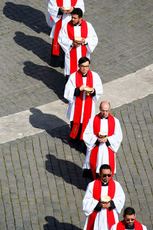 Priests arrive to attend the Palm Sunday Mass in Saint Peter's Square at the Vatican, March 25, 2018 REUTERS/Stefano Rellandini