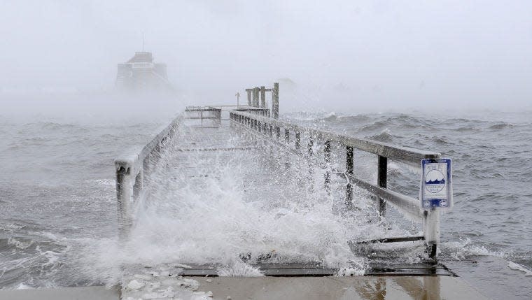 The tidal surge generated from an overnight storm crashes over the Elm Street Pier in Newport in 2014.
