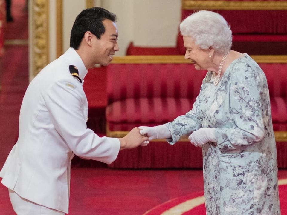 Kevin Vuong in his navy uniform while receiving a leadership award from Queen Elizabeth at Buckingham Palace in 2017. (Kevin Vuong/Facebook - image credit)