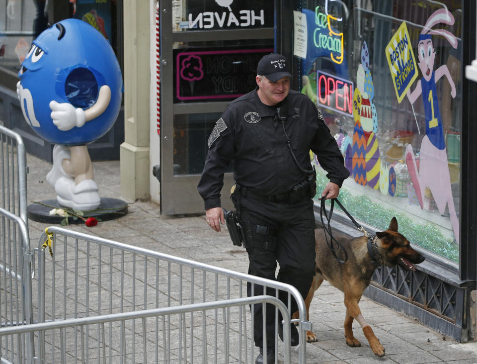 A police officer and his dog patrol Boylston Street near the Boston Marathon finish line Tuesday, April 15, 2014 prior to a remembrance ceremony for family members and survivors of the 2013 Boston Marathon bombing. (AP Photo/Elise Amendola)