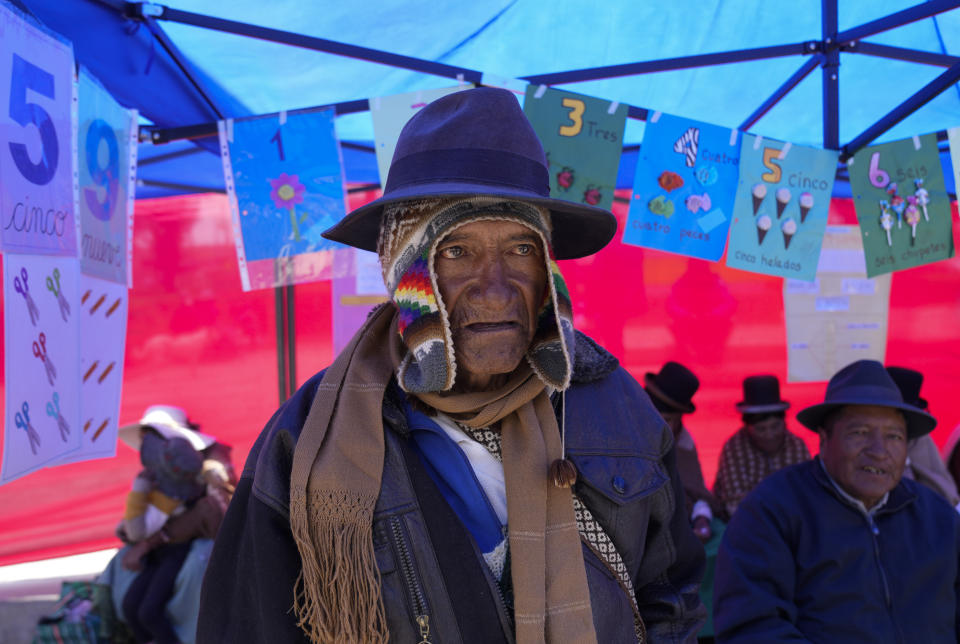 An Aymara man spells out the numbers before receiving his certificate during an adult literacy graduation ceremony in Pucarani, Bolivia, Sunday, Dec. 4, 2022. (AP Photo/Juan Karita)