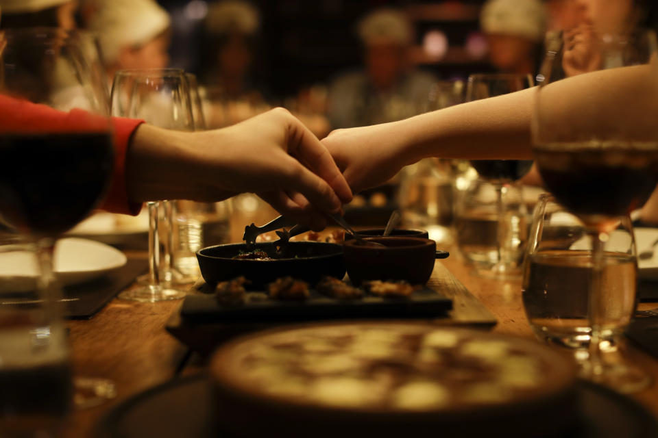 In this March 20, 2017 photo people have dinner at a restaurant during an activity called "The Argentine Experience" in Buenos Aires, Argentina. Tourists participating in "The Argentine Experience" have the chance to learn about the local cuisine, wine and traditions during a dinner in Buenos Aires. (AP Photo/Natacha Pisarenko)
