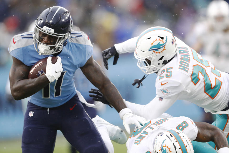 Tennessee Titans wide receiver A.J. Brown (11) gets past Miami Dolphins defenders Miami Dolphins Xavien Howard (25) and Jevon Holland (8) in the first half of an NFL football game Sunday, Jan. 2, 2022, in Nashville, Tenn. (AP Photo/Wade Payne)