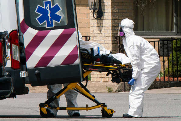 Medical workers load a dead body from Andover Subacute and Rehabilitation Center into an ambulance while wearing masks and personal protective equipment (PPE) in Andover, New Jersey. 