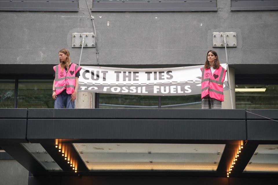 Two activists climbed onto the portico and set off the canisters while another chained himself to a handrail (PA)