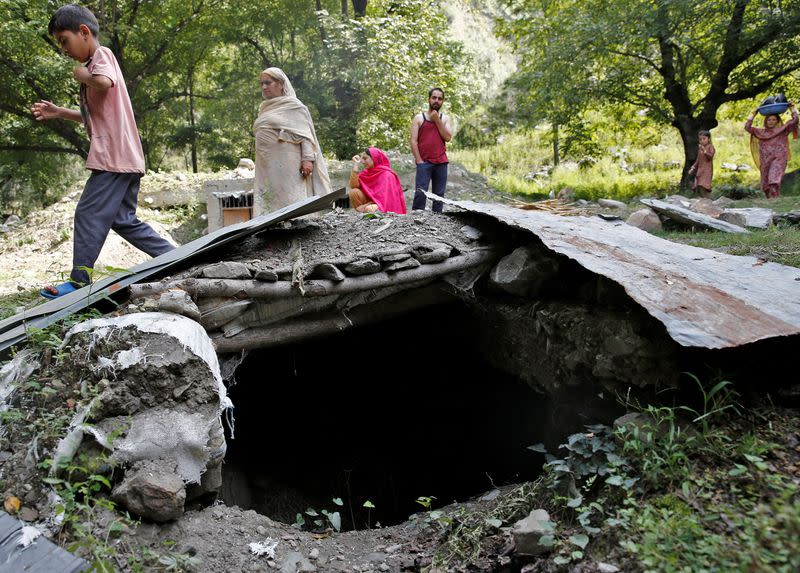 Villagers move past a bunker that they said was built to take shelter in the wake of exchange of gun fire between Indian and Pakistani soldiers near the Line of Control between India and Pakistan in Teetwal