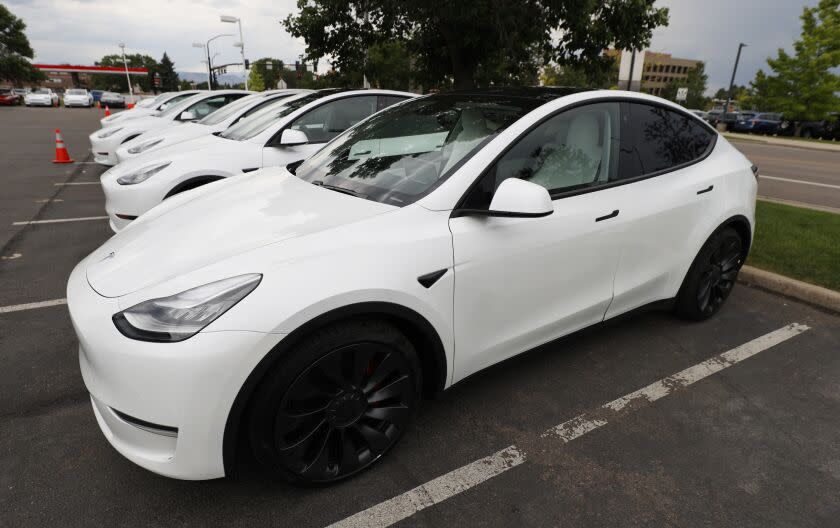 In this Sunday, June 28, 2020, photograph, a long line of unsold 2020 Model Y sports-utility vehicles sits at a Tesla dealership in Littleton, Colo. (AP Photo/David Zalubowski)