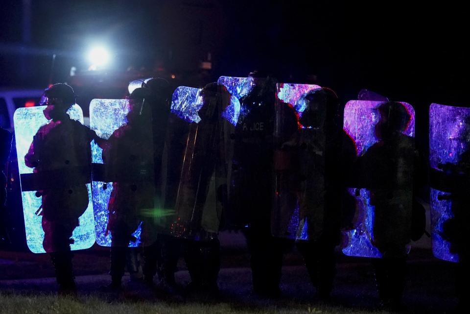 Police in riot gear line up Friday, Oct. 9, 2020, in Wauwatosa, Wis. On Wednesday, District Attorney John Chisholm declined to charge Wauwatosa police Officer Joseph Mensah in the February fatal shooting of 17-year-old Alvin Cole outside a mall. (AP Photo/Morry Gash)