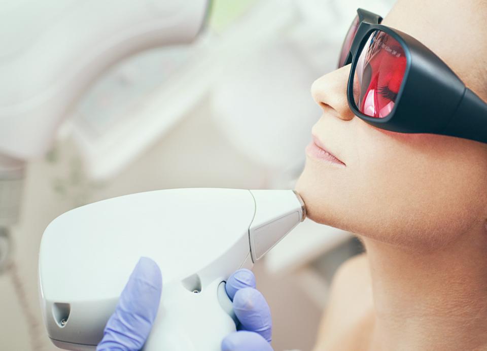 Woman receiving a laser hair removal treatment on her chin.