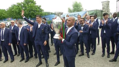 Portugal's winning EURO 2016 team appear with the cup, in this still image grabbed from video, outside their base camp in Marcoussis, France, July 11, 2016. REUTERS/Noemie Olive