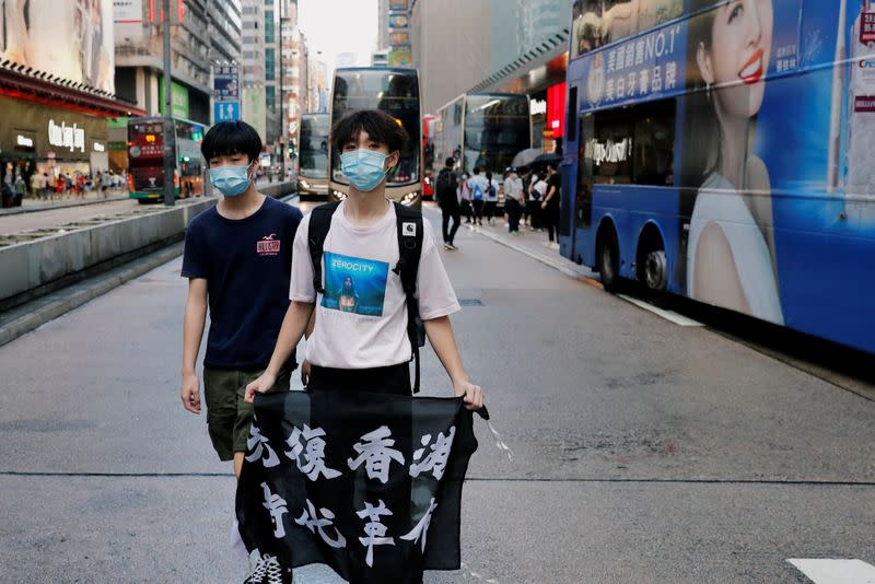 FILE PHOTO: An anti-government protester holds a flag with Chinese calligraphy that reads "Liberate Hong Kong, the revolution of our times", during a protest at Mong Kok, in Hong Kong