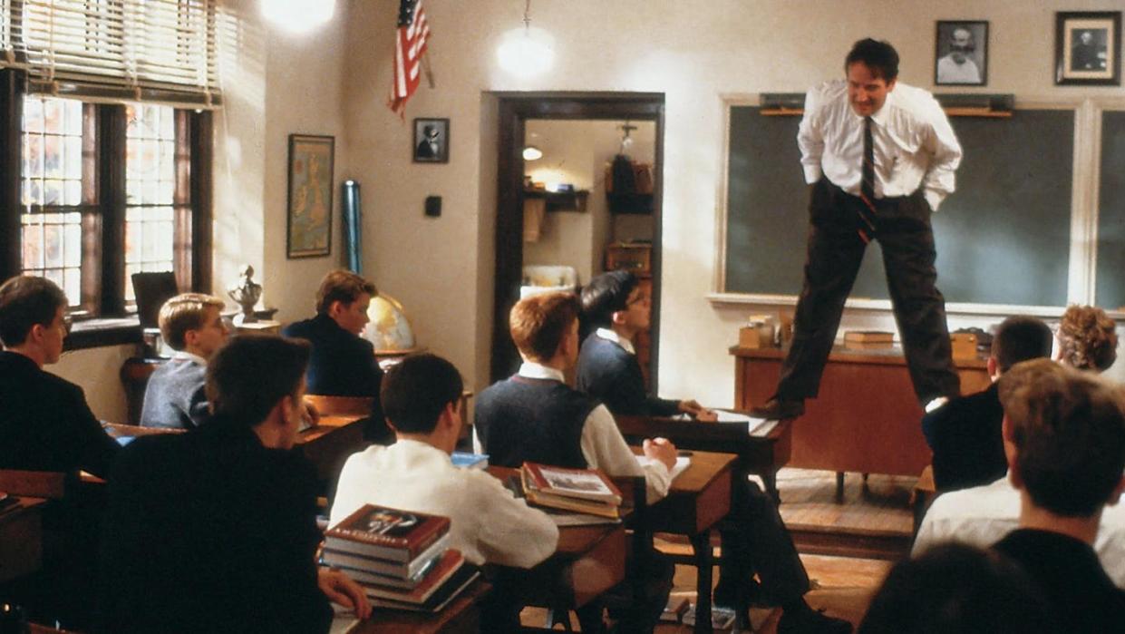 Escena de la película 'El club de los poetas muertos', con Robin Williams interpretando al profesor subido a una mesa de la clase. <a href="https://www.filmaffinity.com/es/filmimages.php?movie_id=315826" rel="nofollow noopener" target="_blank" data-ylk="slk:FilmAffinity;elm:context_link;itc:0;sec:content-canvas" class="link ">FilmAffinity</a>