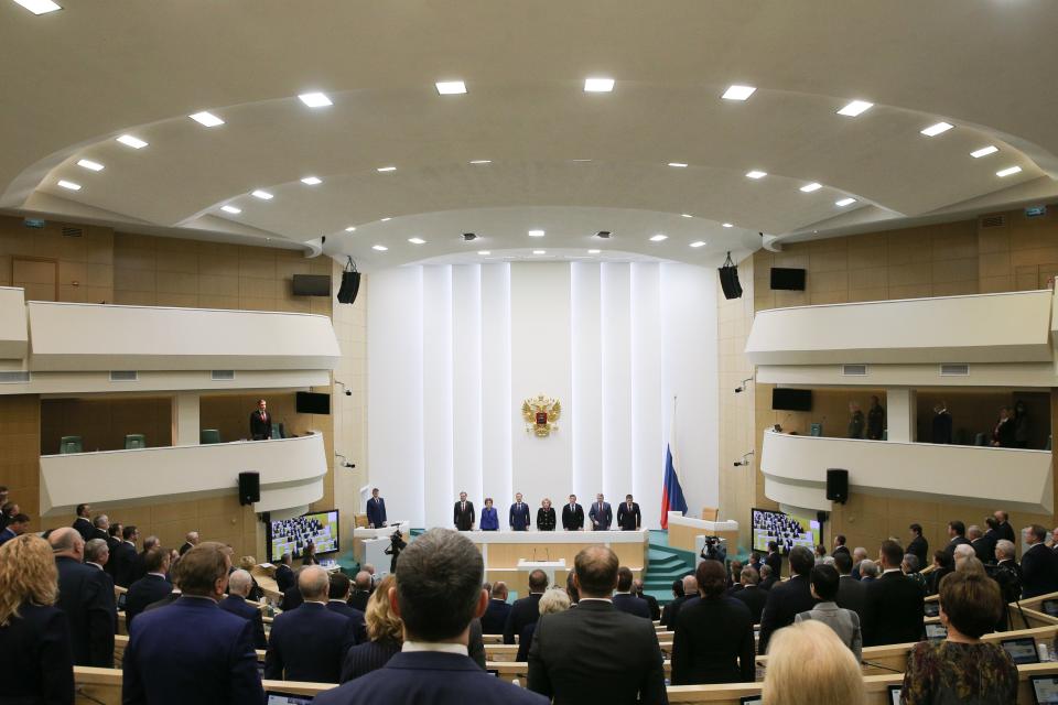 Lawmakers of Federation Council of the Federal Assembly of the Russian Federation listen to the national anthem attending a session in Moscow, Russia, Tuesday, Feb. 22, 2022. Lawmakers gave Russian President Vladimir Putin permission to use military force outside the country on Tuesday. Several European leaders said earlier in the day that Russian troops have moved into rebel-held areas in eastern Ukraine after Putin recognized their independence. (Federation Council of the Federal Assembly of the Russian Federation via AP)