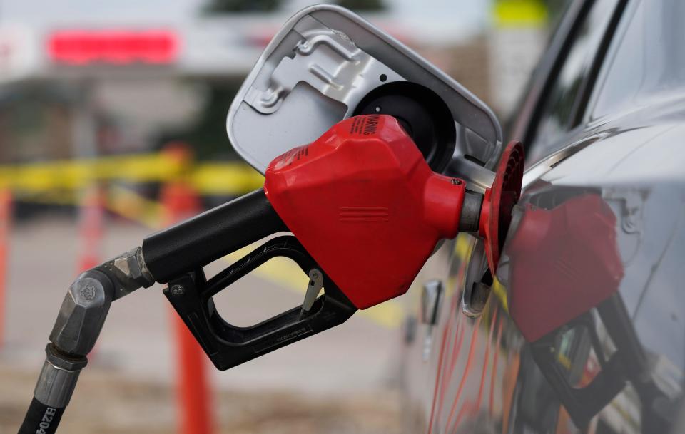 A motorist fills up the tank on a sedan, on July 22, 2022, in Saratoga, Wyo.