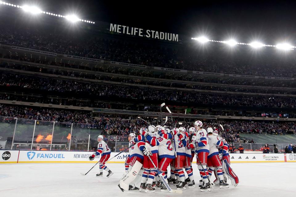 Feb 18, 2024; East Rutherford, New Jersey, USA; New York Rangers players celebrate after defeating the New York Islanders during the overtime period of a Stadium Series ice hockey game at MetLife Stadium.