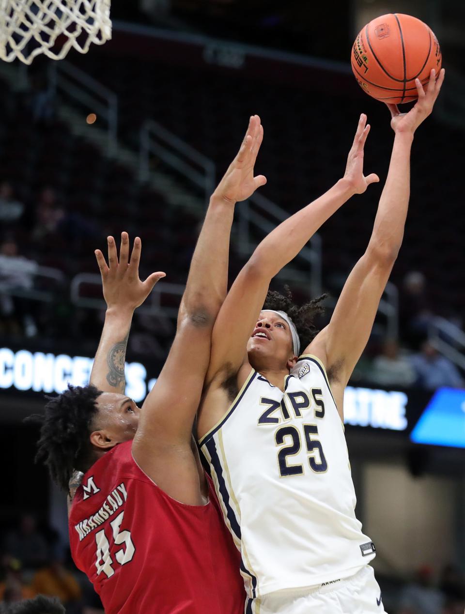 Akron Zips forward Enrique Freeman (25) shoots over Miami (OH) Redhawks center Anderson Mirambeaux (45) during the first half of an NCAA college basketball game in the quarterfinals of the Mid-American Conference Tournament at Rocket Mortgage FieldHouse, Thursday, March 14, 2024, in Cleveland, Ohio.