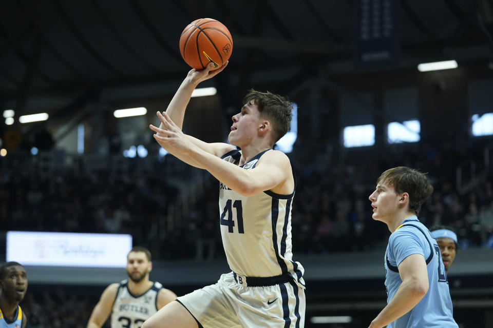 Butler's Simas Lukosius (41) shoots against Marquette's Tyler Kolek, front right, during the first half of an NCAA college basketball game, Saturday, Feb. 12, 2022, in Indianapolis. (AP Photo/Darron Cummings)